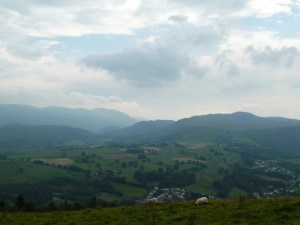 Hazy Helvellyn beyond the dark looking Central Fells